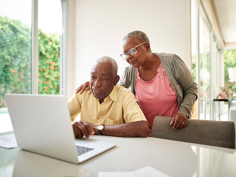 Older couple checking eligibility with laptop